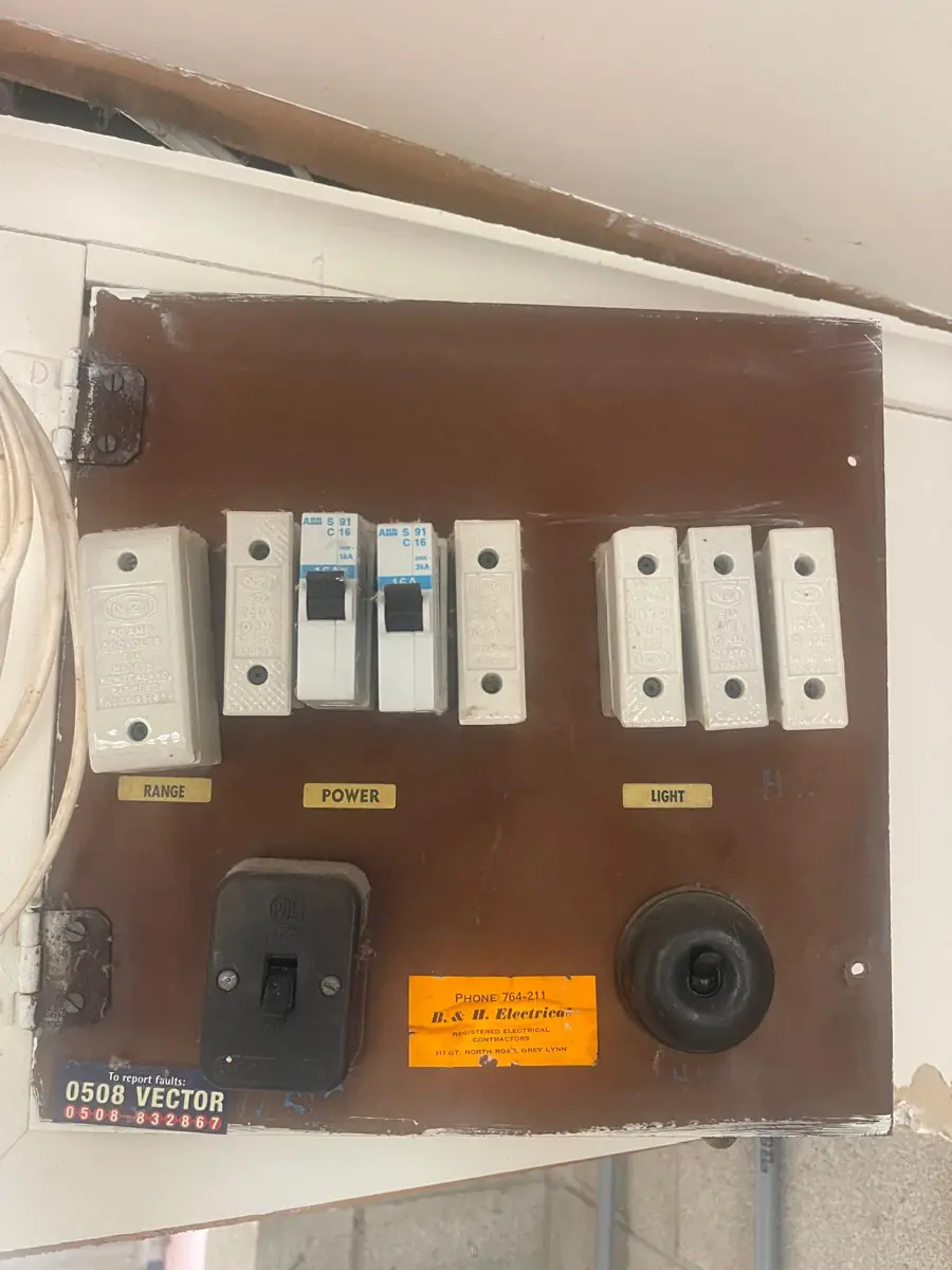 A 1960s domestic fuseboard with ceramic rewireable fuses and no RCD protection, still in service